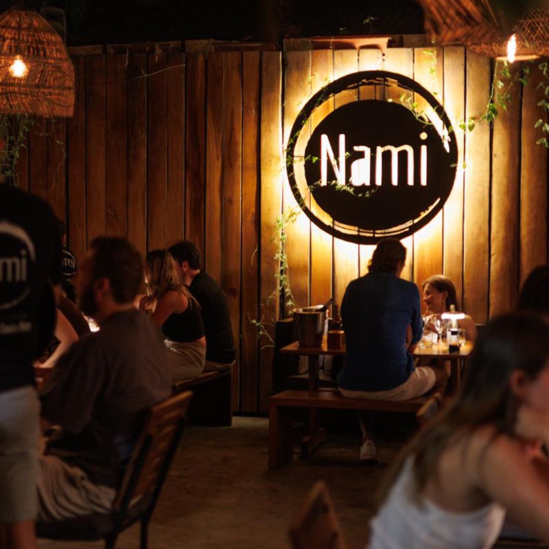 People dining in a cozy, dimly lit restaurant named Nami.
