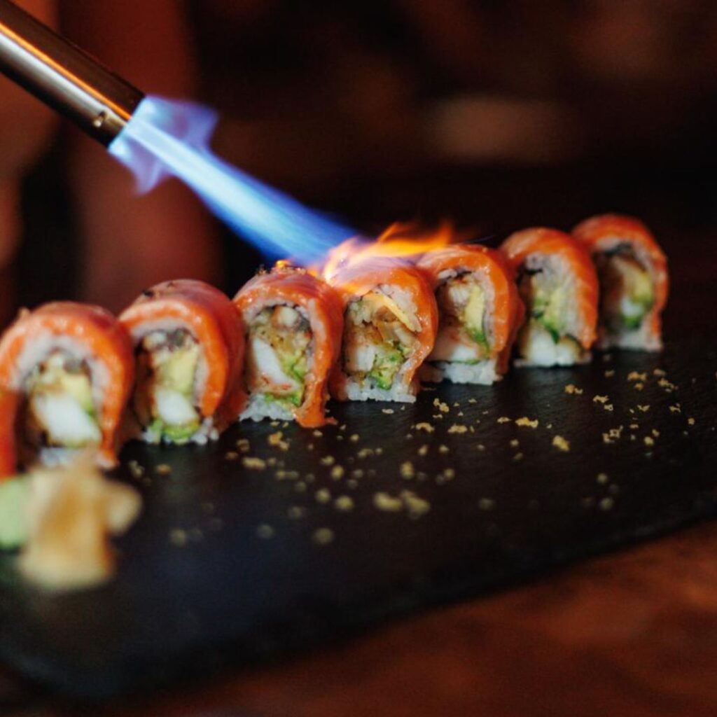 Sushi rolls being torched for a smoky finish.