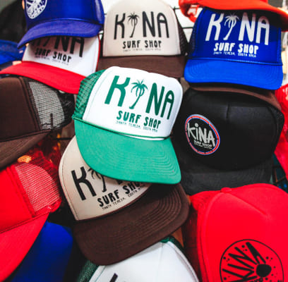 Colorful K7NA branded caps with various logos and designs.