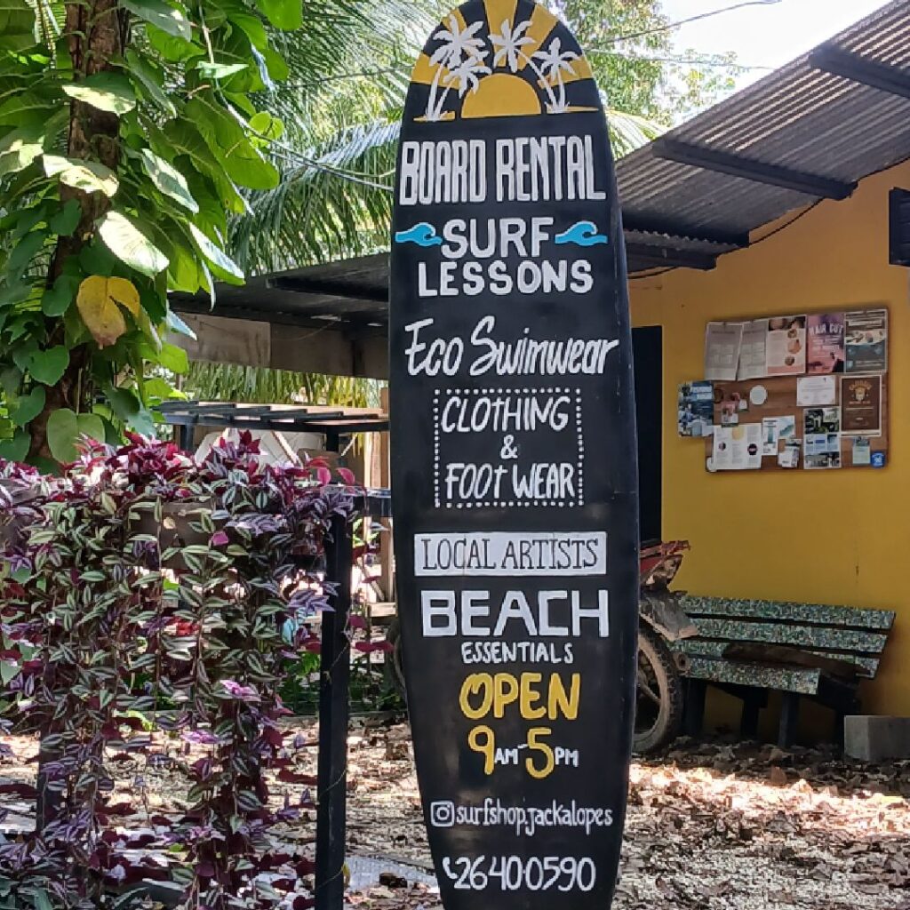 A colorful surf shop sign offering lessons and beach rentals.