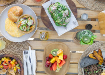 Blue Mist restaurant in Santa Teresa serving a beachfront breakfast with Pinto con Huevos, tropical fruit bowl, fresh breads, and a superfood drink overlooking the Pacific Ocean