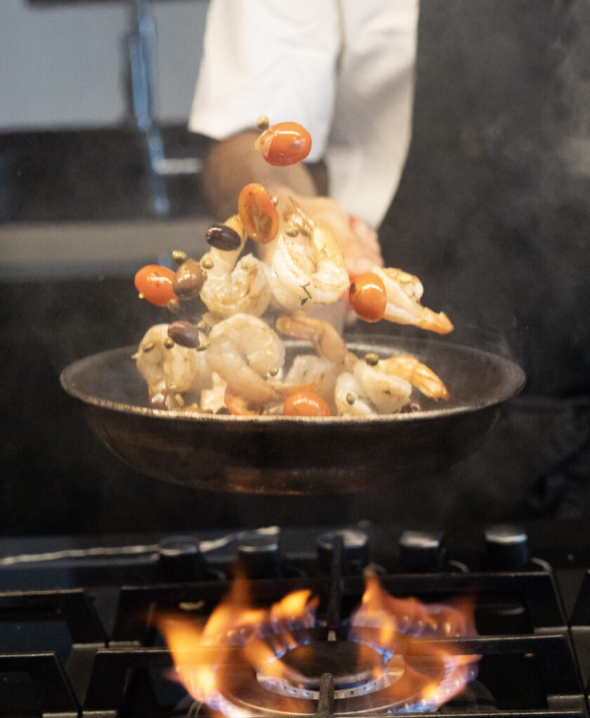 Chef tossing shrimp and vegetables over open flame in Santa Teresa Costa Rica