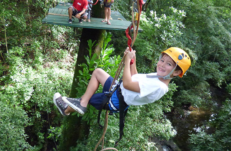 Child ziplining in jungle canopy Mal País Costa Rica