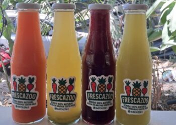 Four glass bottles of Frescazoo fresh juice in Santa Teresa Costa Rica featuring carrot, starfruit, beet carrot ginger, and pineapple basil blends made with local ingredients.