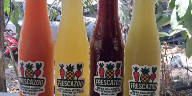 Four glass bottles of Frescazoo fresh juice in Santa Teresa Costa Rica featuring carrot, starfruit, beet carrot ginger, and pineapple basil blends made with local ingredients.