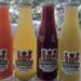 Four glass bottles of Frescazoo fresh juice in Santa Teresa Costa Rica featuring carrot, starfruit, beet carrot ginger, and pineapple basil blends made with local ingredients.