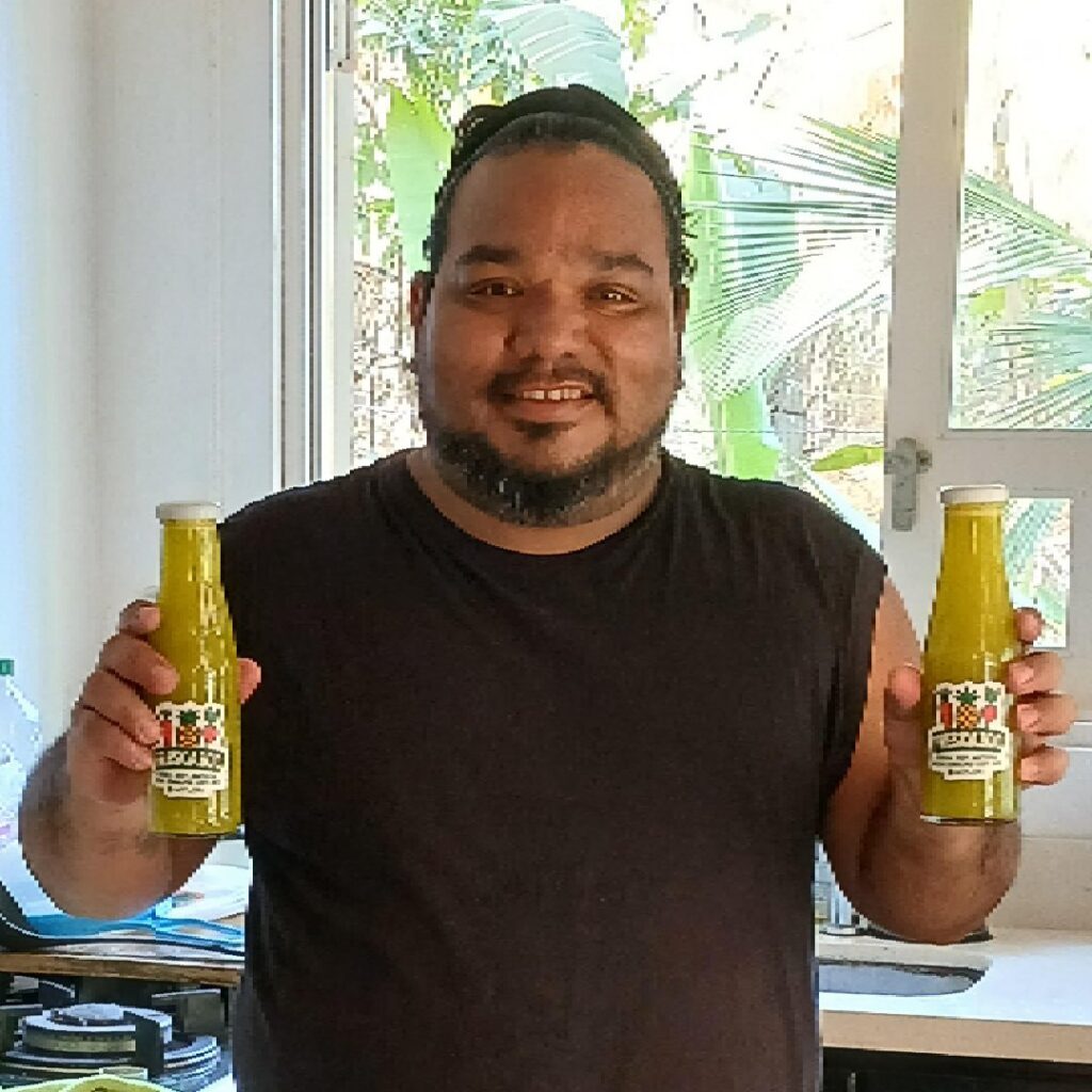 Cholo holding two glass bottles of Frescazoo fresh juice in Santa Teresa Costa Rica featuring pineapple basil blend made from local ingredients.