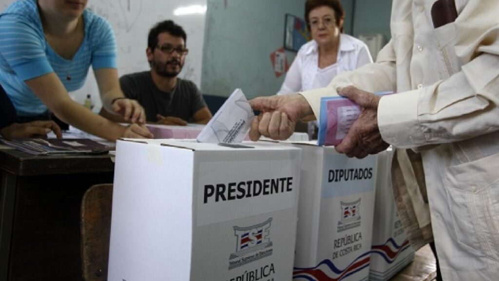Voter placing ballot into official election box during Costa Rica’s 2026 presidential election.