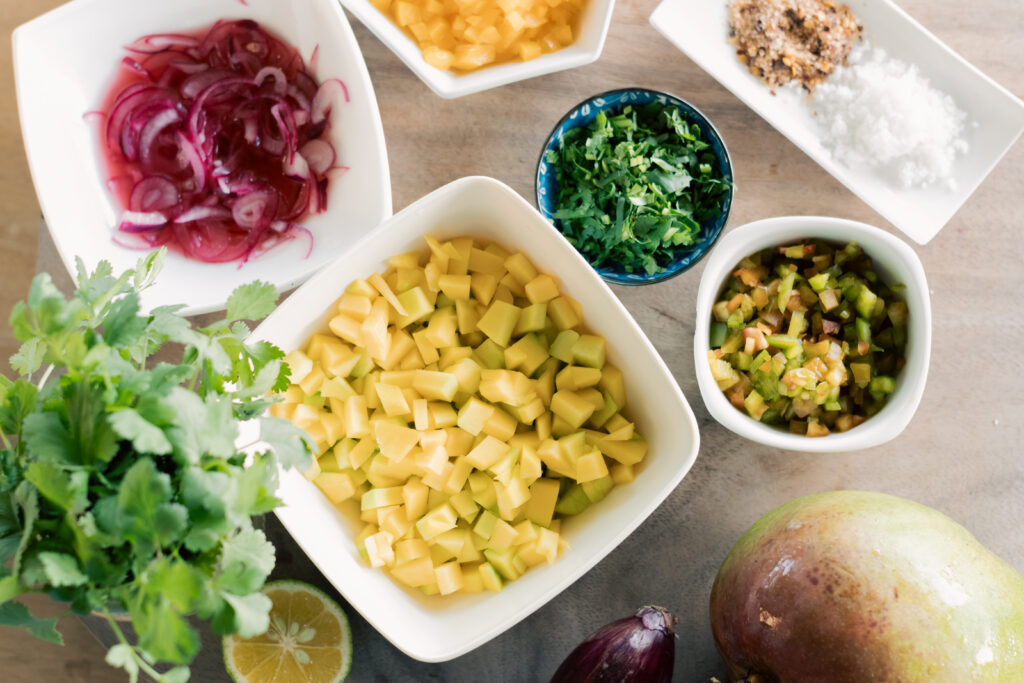 Fresh ingredients for green mango ceviche including green mango lime red onion cilantro chili Costa Rica