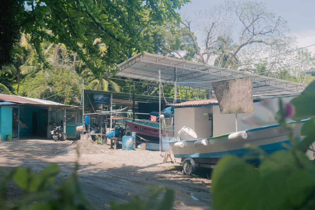 Malpais fishing village boats on shore Costa Rica fishermen filleting fish by the ocean