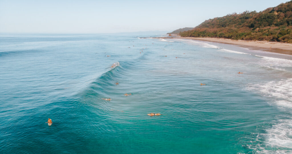 surfers floating in calm ocean with visible currents Costa Rica