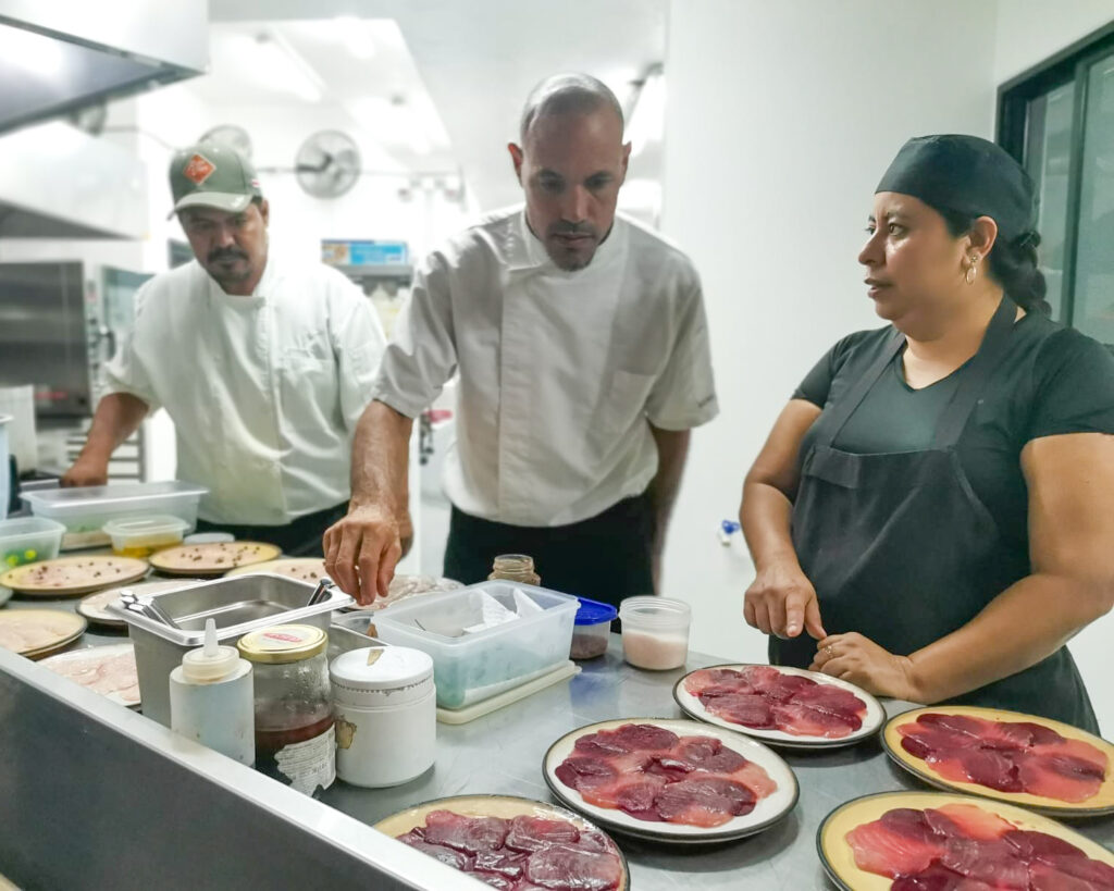 Chef Eitan and kitchen team plating dishes in busy restaurant kitchen