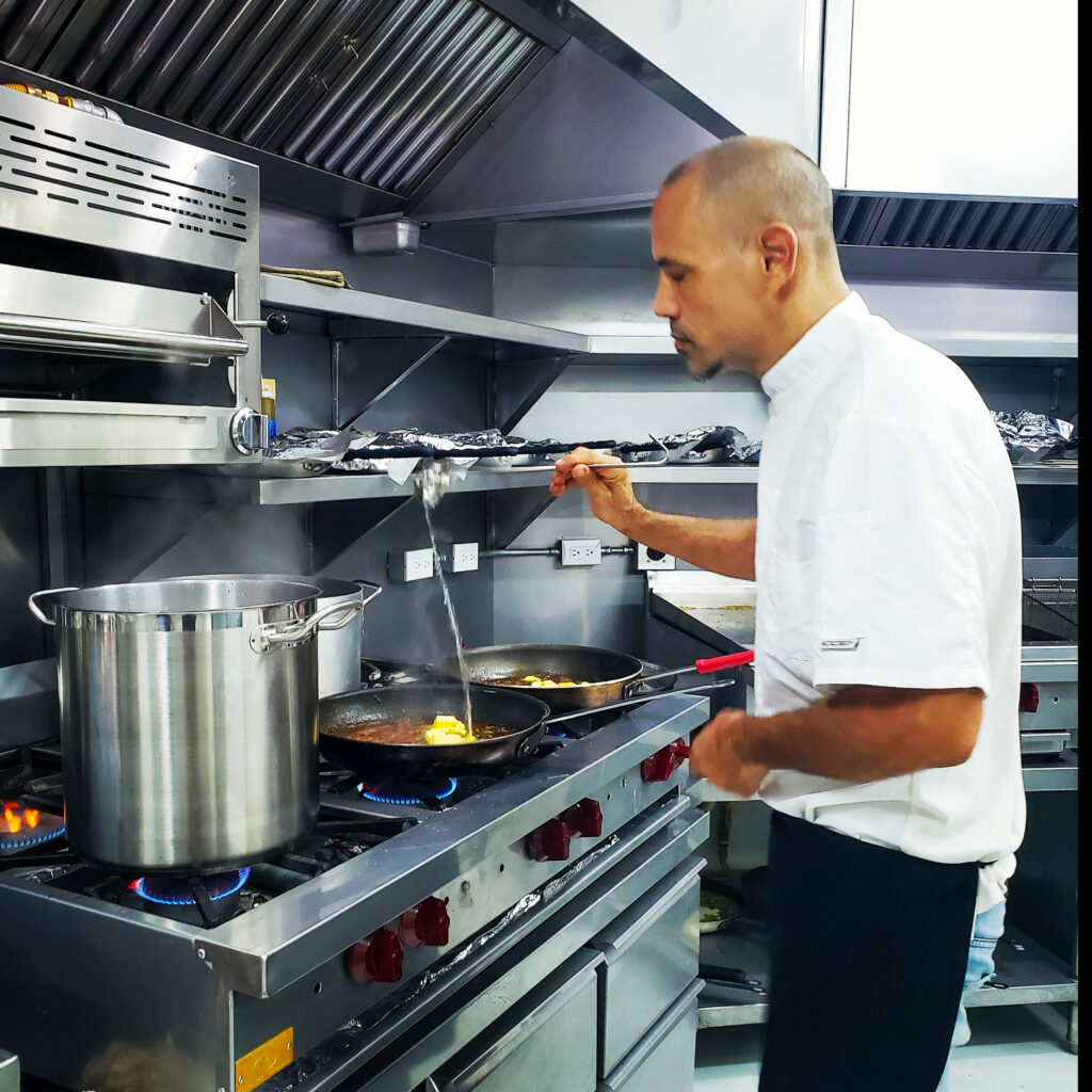 Chef Eitan cooking sauce with care in professional kitchen Costa Rica