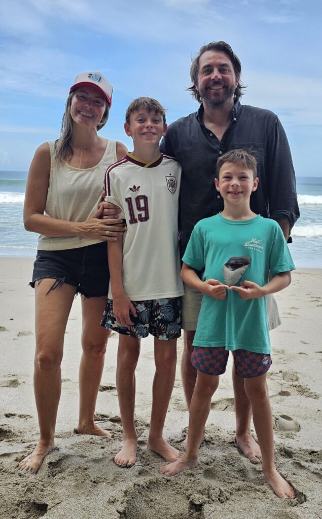 Family celebrating together on Santa Teresa Beach after discovering a prehistoric Megalodon shark tooth.