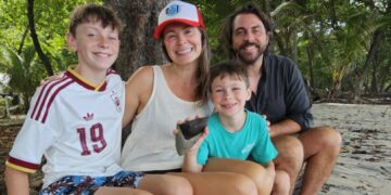 family from Atlanta relaxing on Santa Teresa Beach after their son discovered a fossilized Megalodon shark tooth during their Costa Rica vacation.